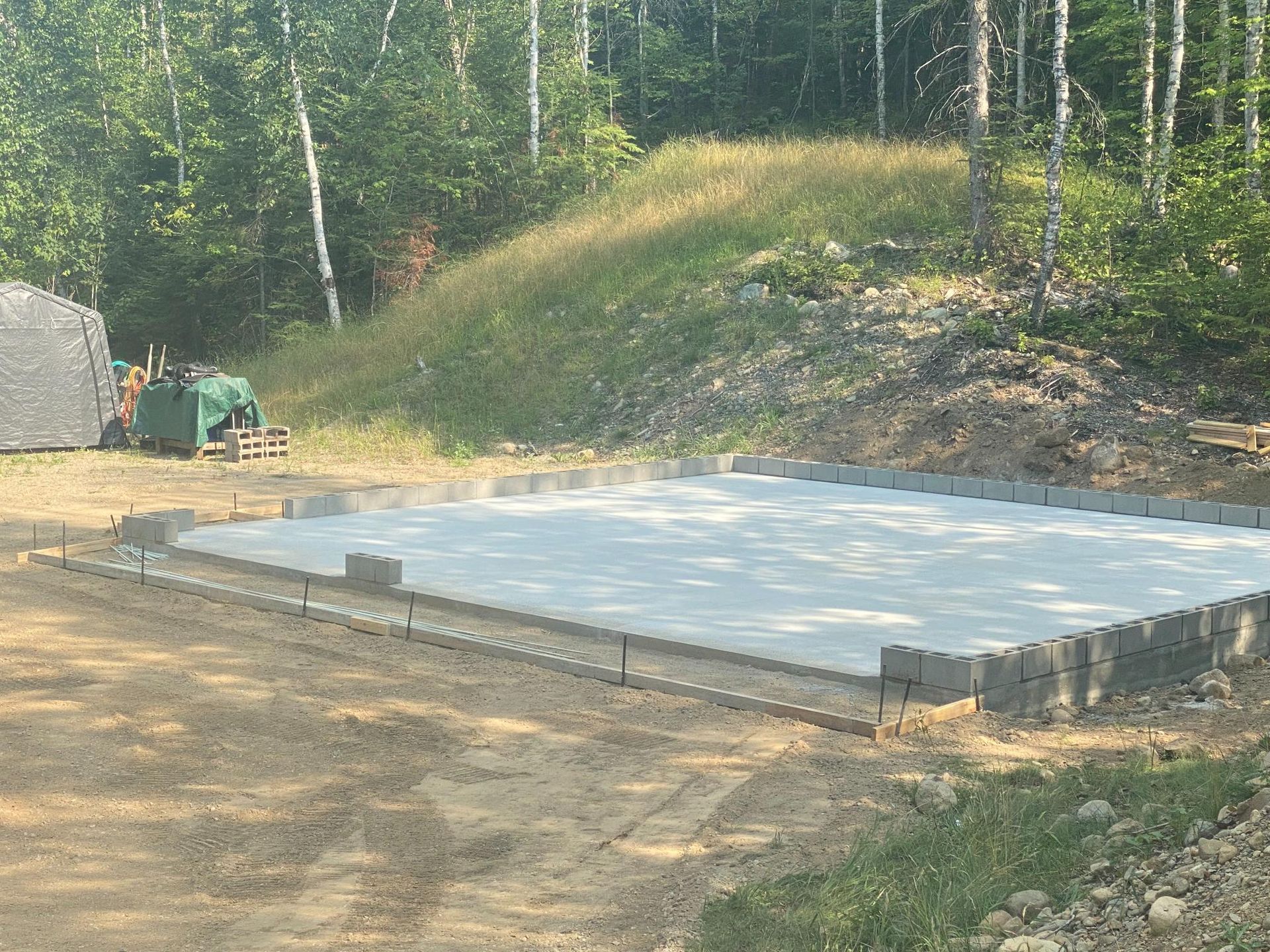 A large concrete slab is sitting in the middle of a dirt field.