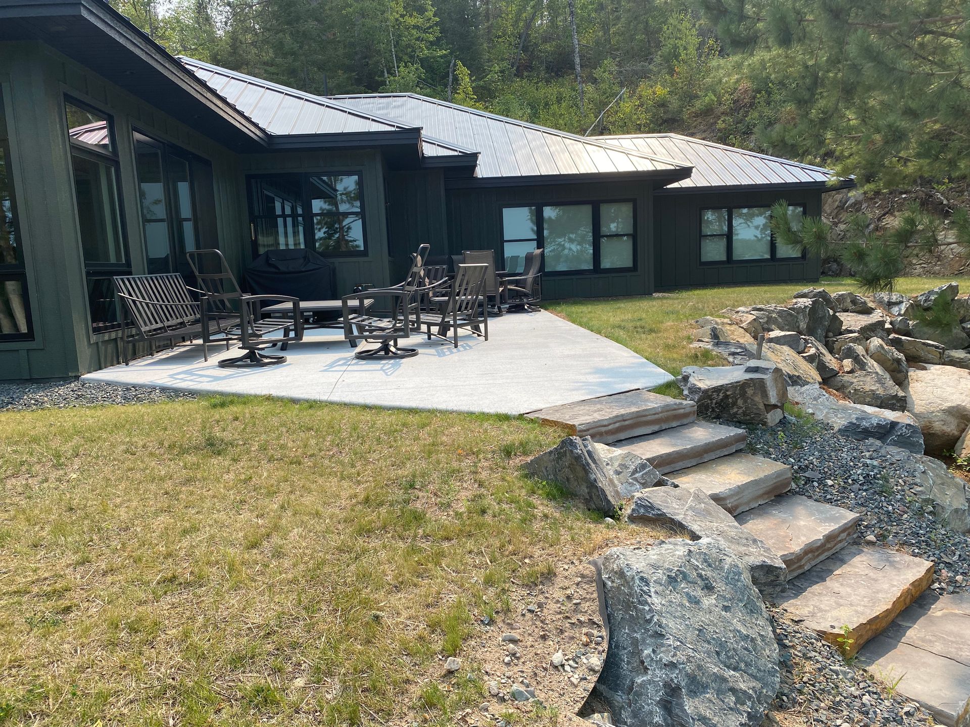 A large house with a patio and chairs in front of it.