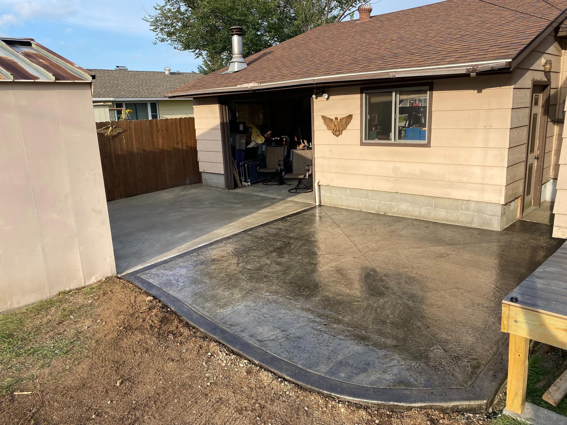 A concrete driveway is being built in front of a house.