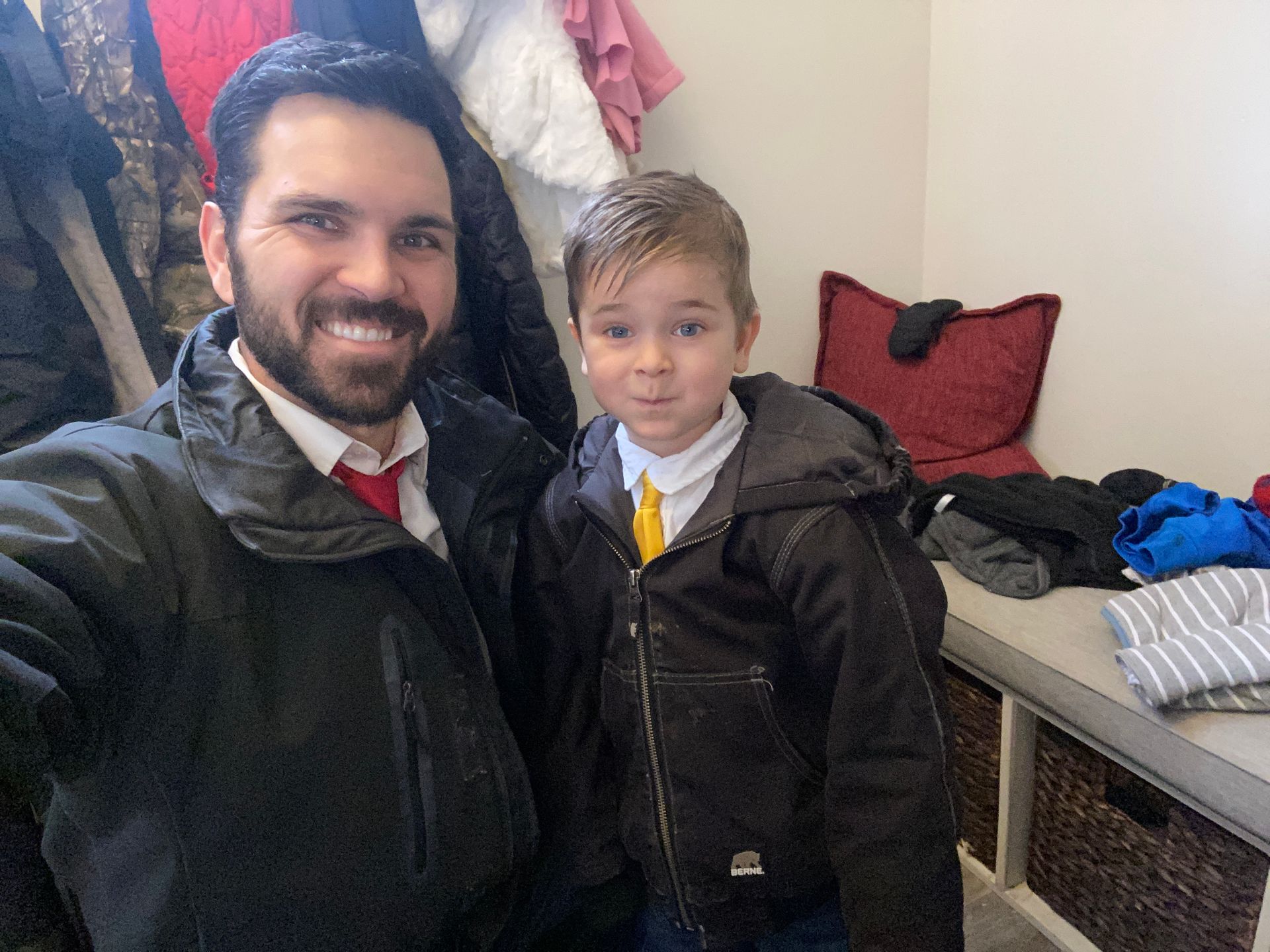 A man and a boy are standing next to each other in a room.