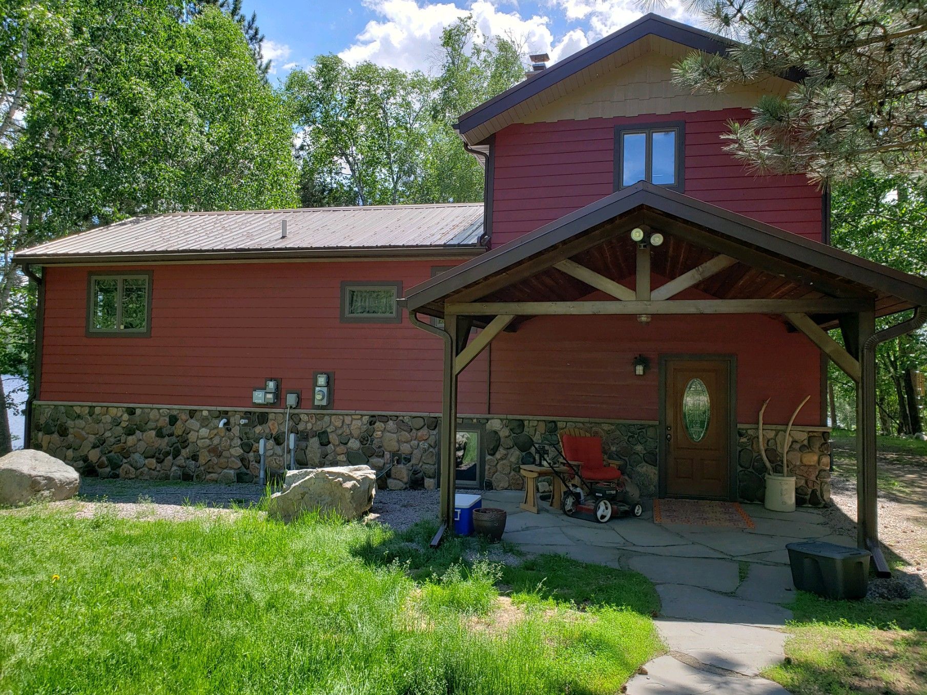 A red house with a porch and a stroller in front of it.