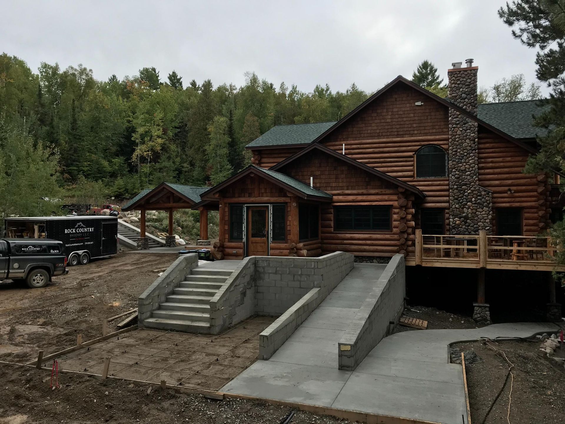A large log cabin with stairs leading up to it