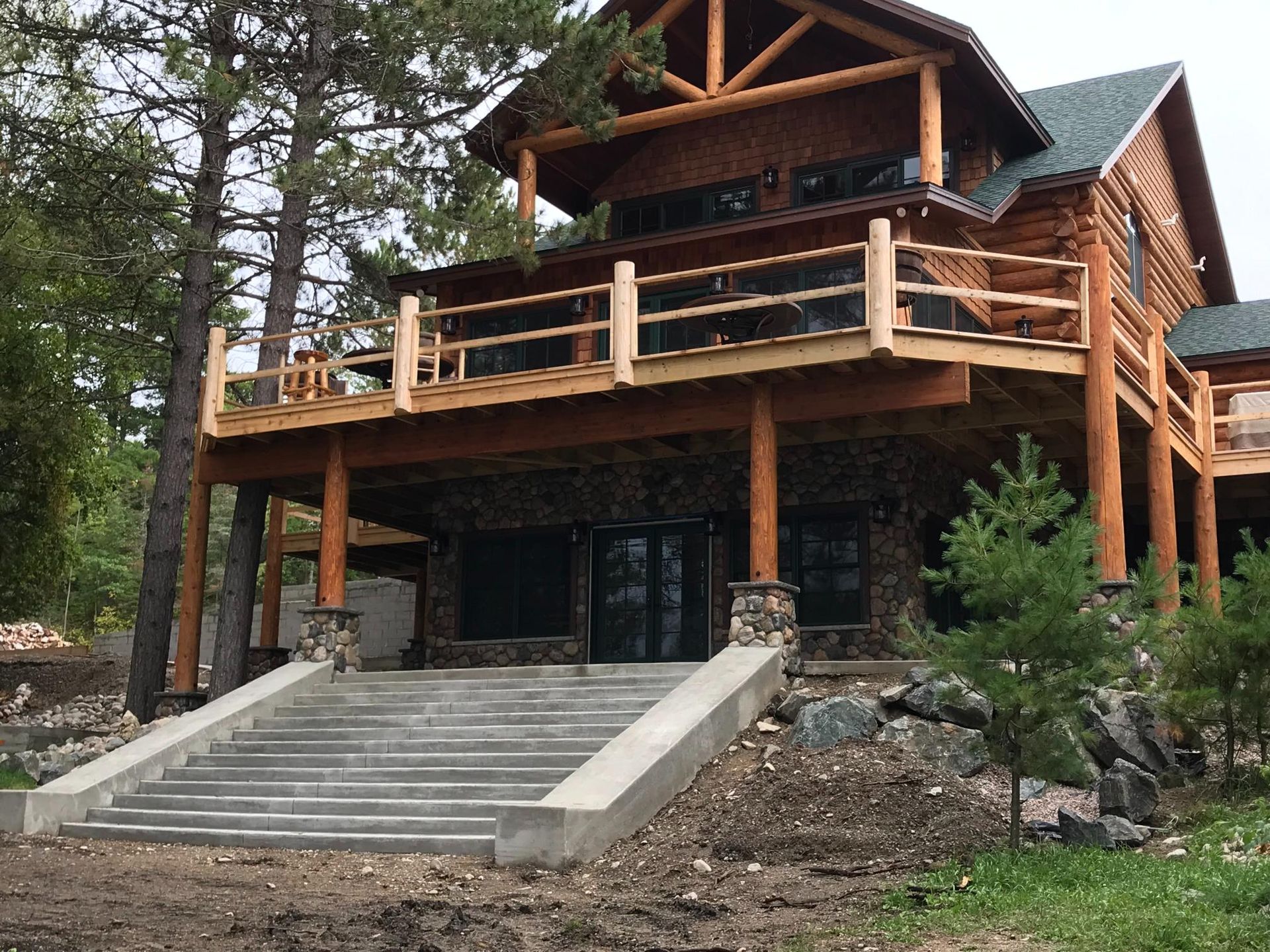 A large log cabin with stairs leading up to it