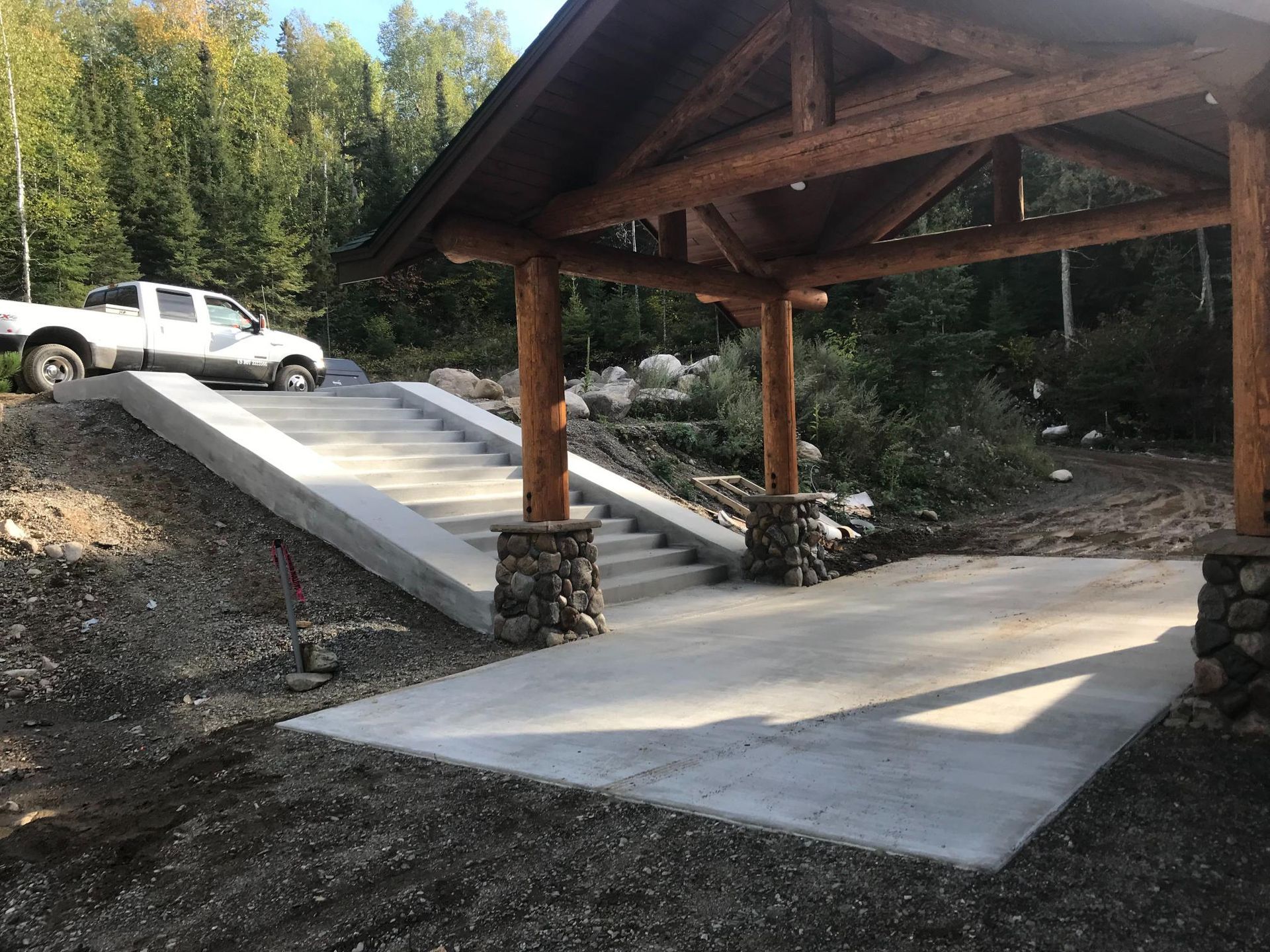 A white truck is parked in front of a wooden structure.