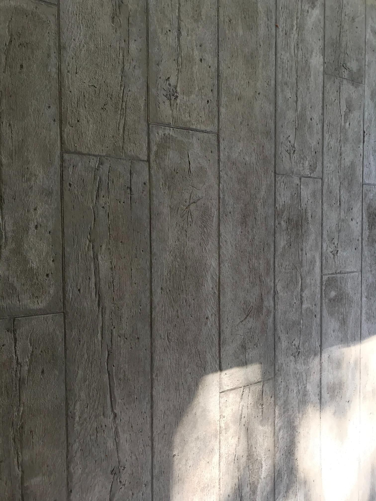 A close up of a concrete wall with a shadow of a person on it.