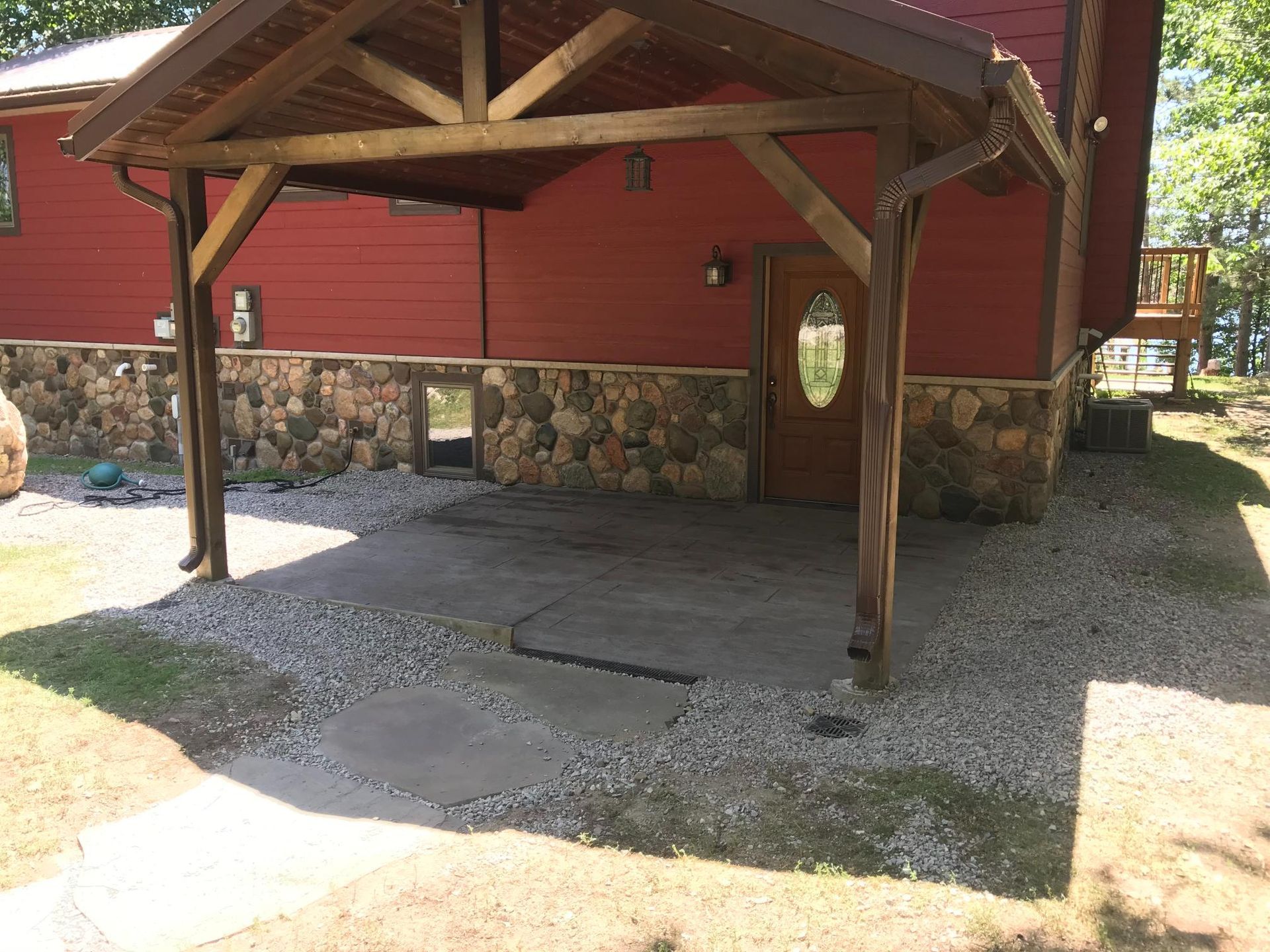 A red house with a wooden porch in front of it.