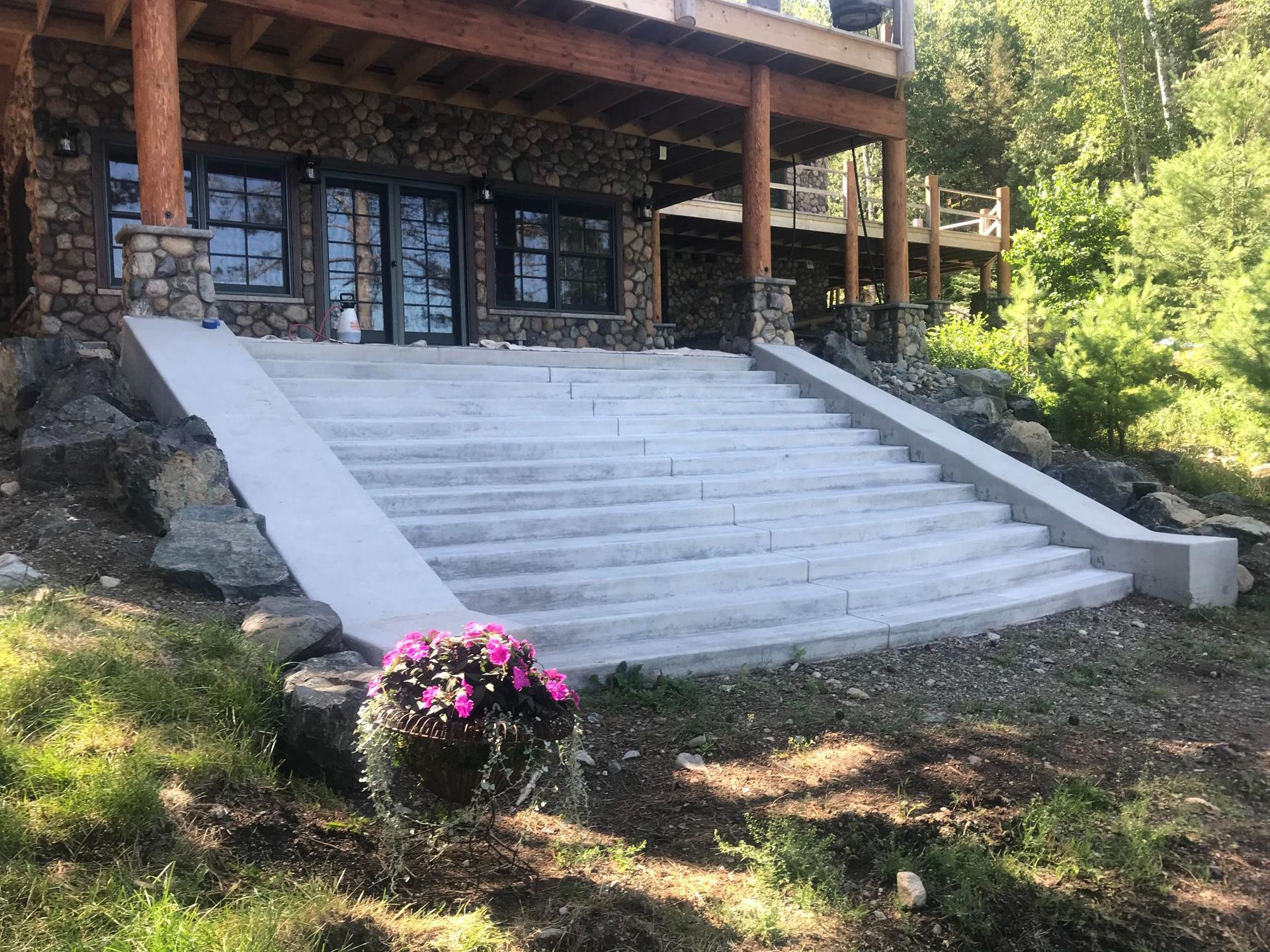 A set of concrete stairs leading up to a stone building.