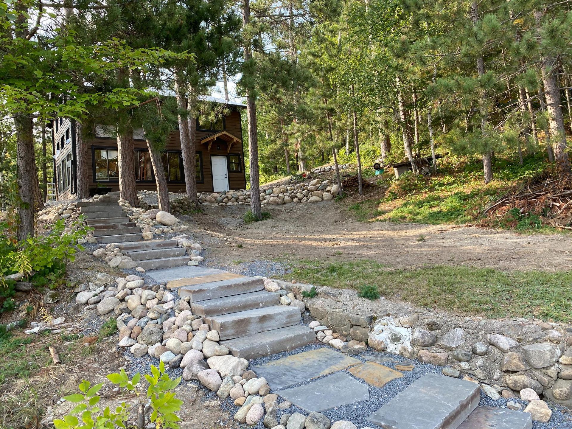 A stone path leading to a house in the woods.