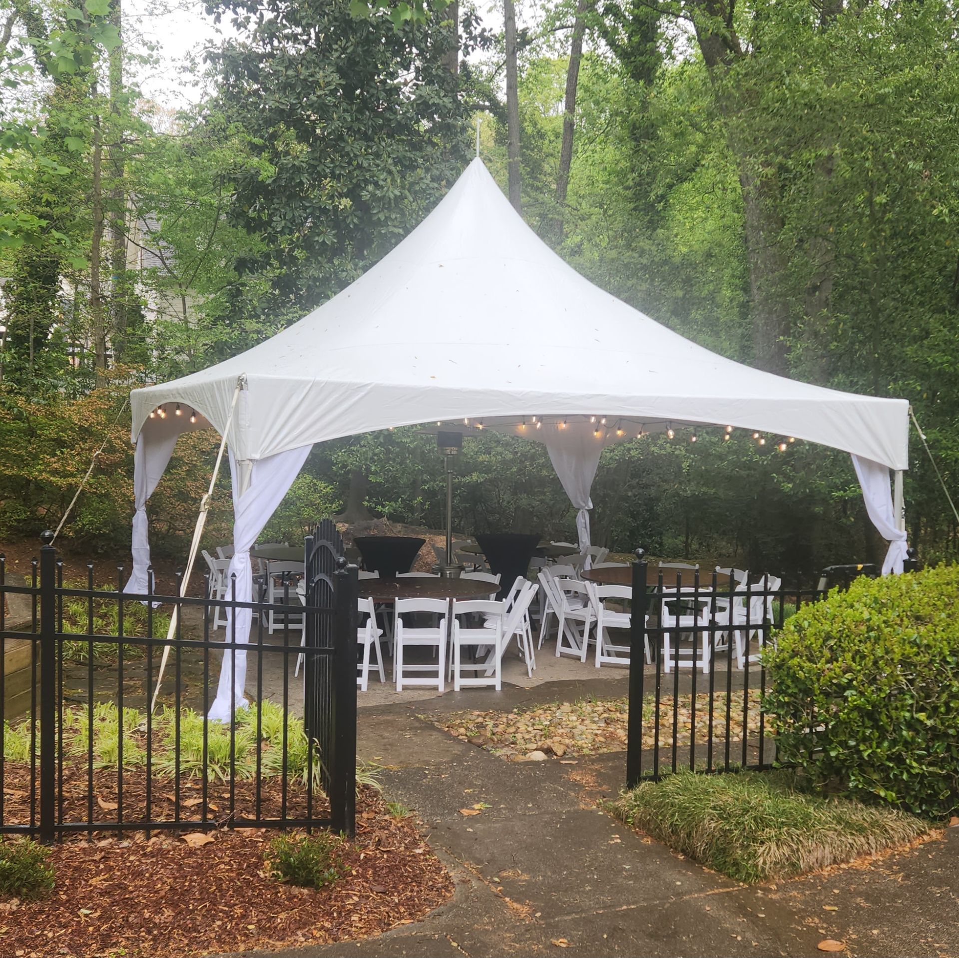 A white tent with white chairs underneath it