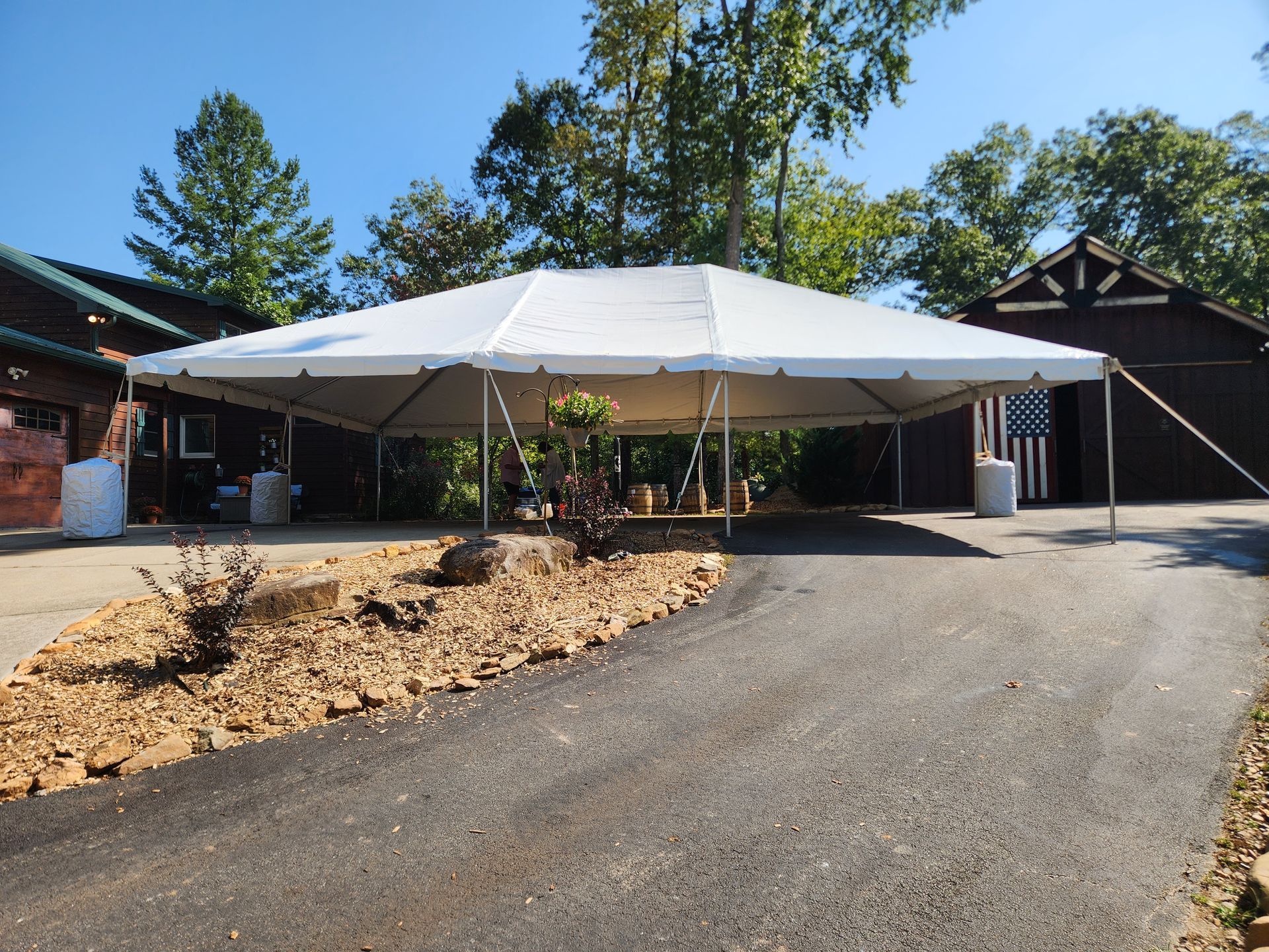 A large white tent is in the driveway of a house