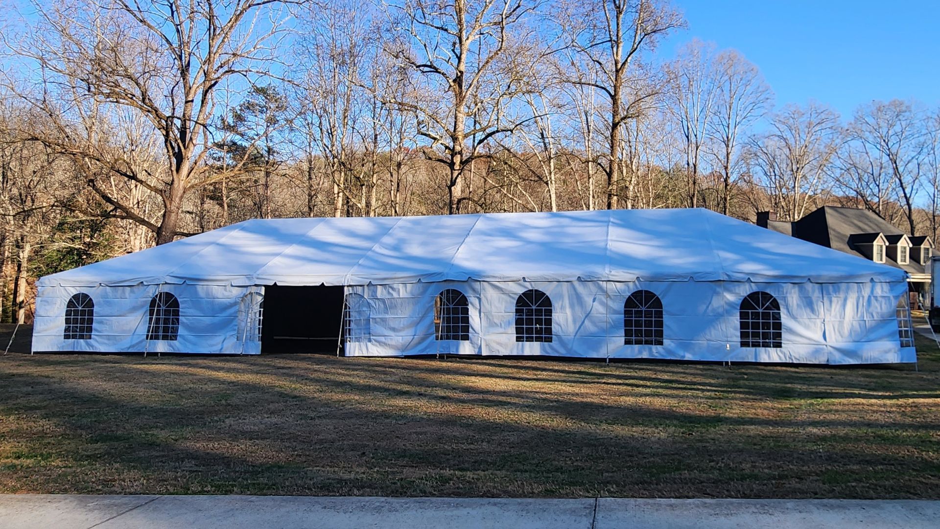 A large white tent is sitting in the middle of a field.