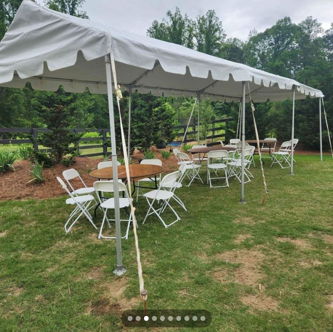A white tent with tables and chairs underneath it