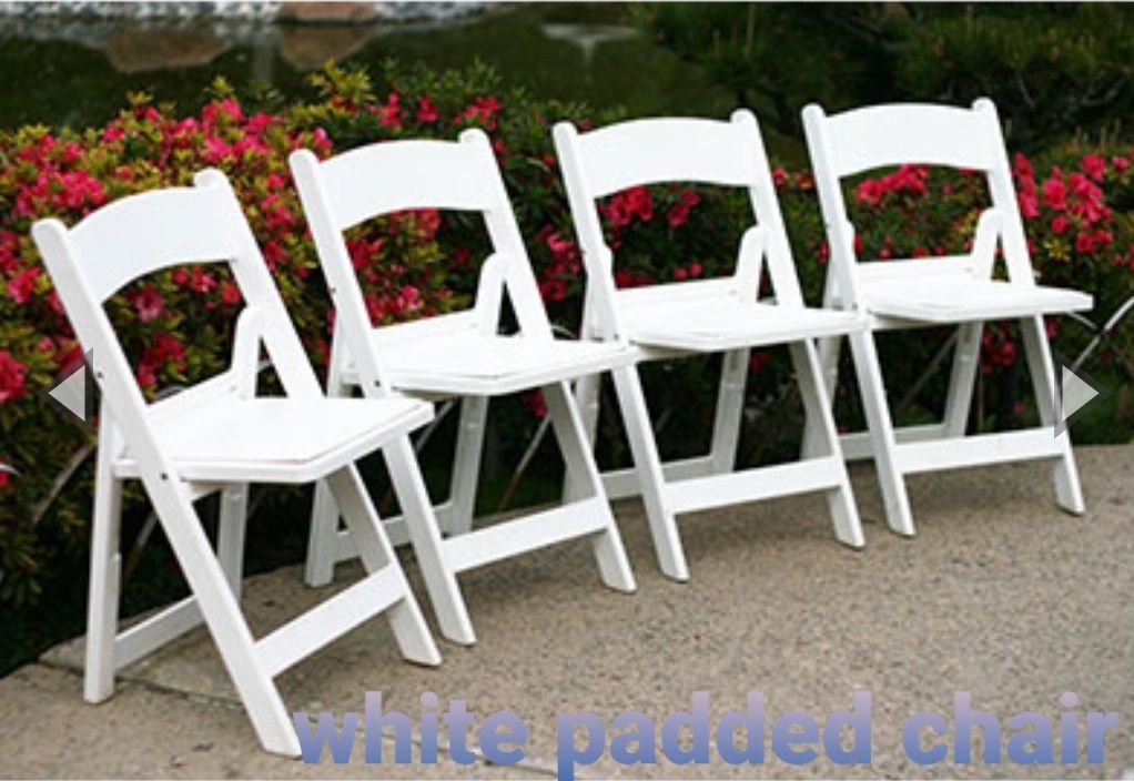 Four white padded folding chairs are lined up in a row