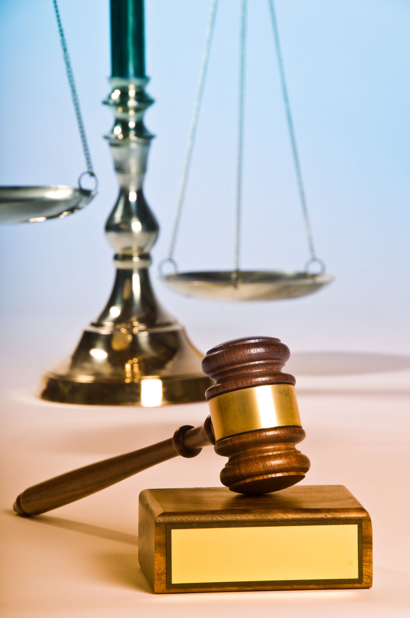 Gavel and scales on a blue background, symbolizing law and order by a criminal defense attorney. Gavel and scales on a blue background, symbolizing law and order by a criminal defense attorney.