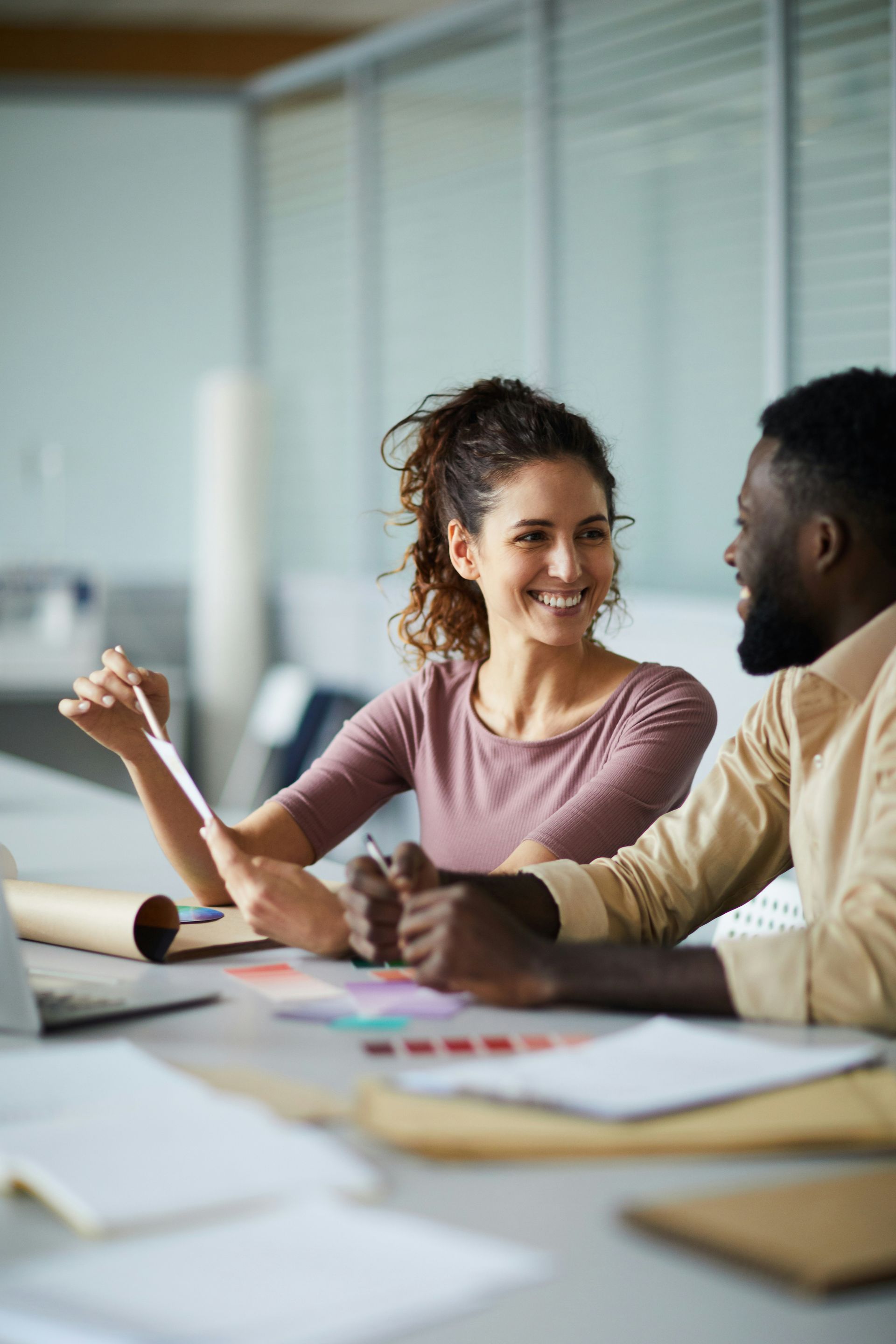 A woman in a red dress is standing on a beach looking at the ocean.