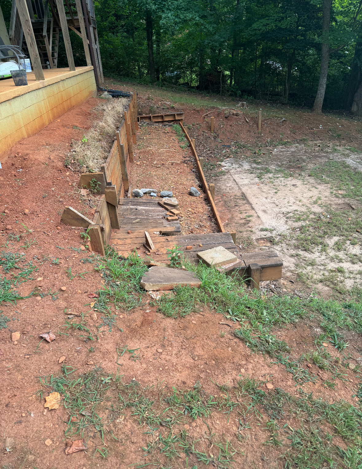 A wooden bench is sitting in the middle of a dirt field.