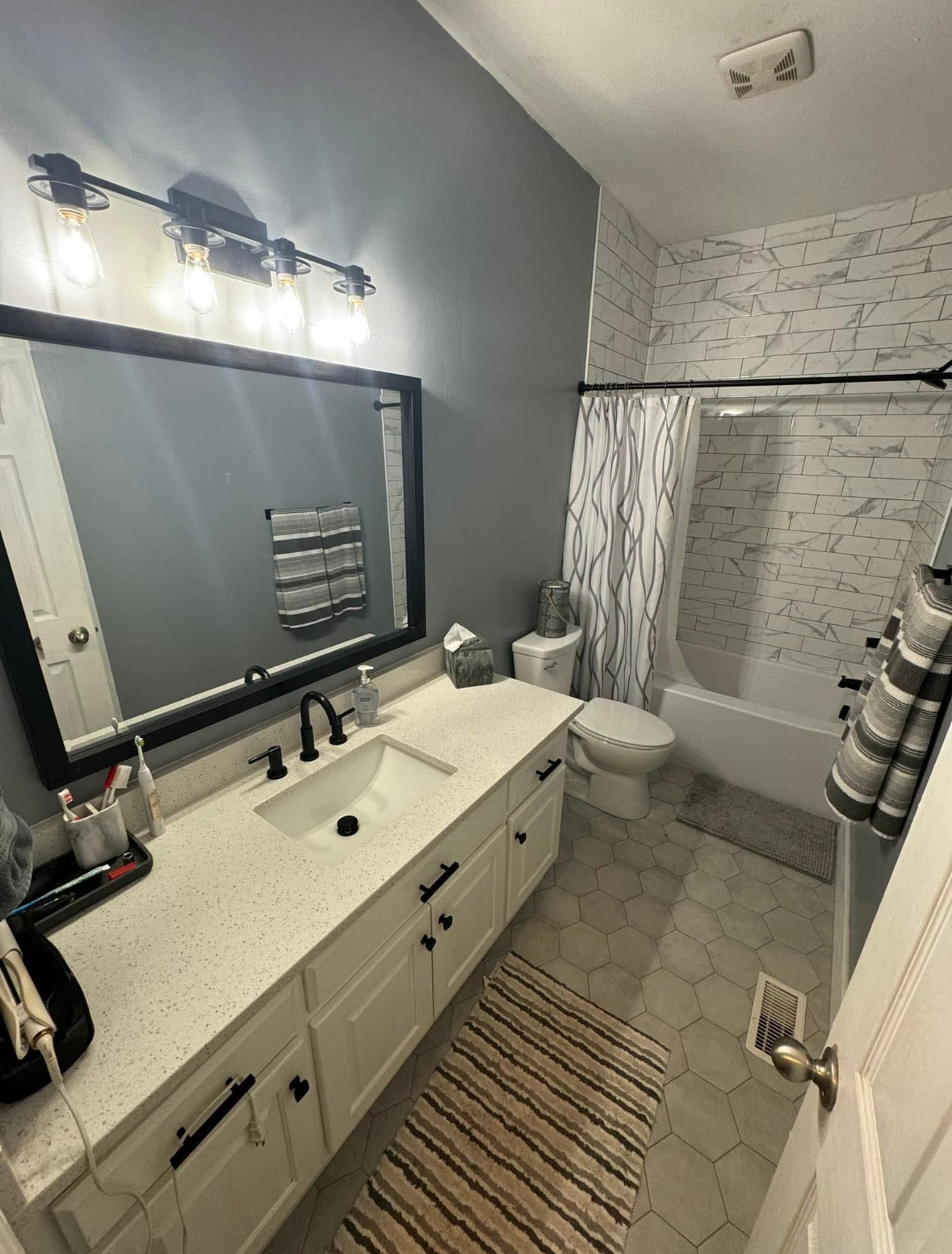 A bathroom with a sink , toilet , bathtub and mirror.