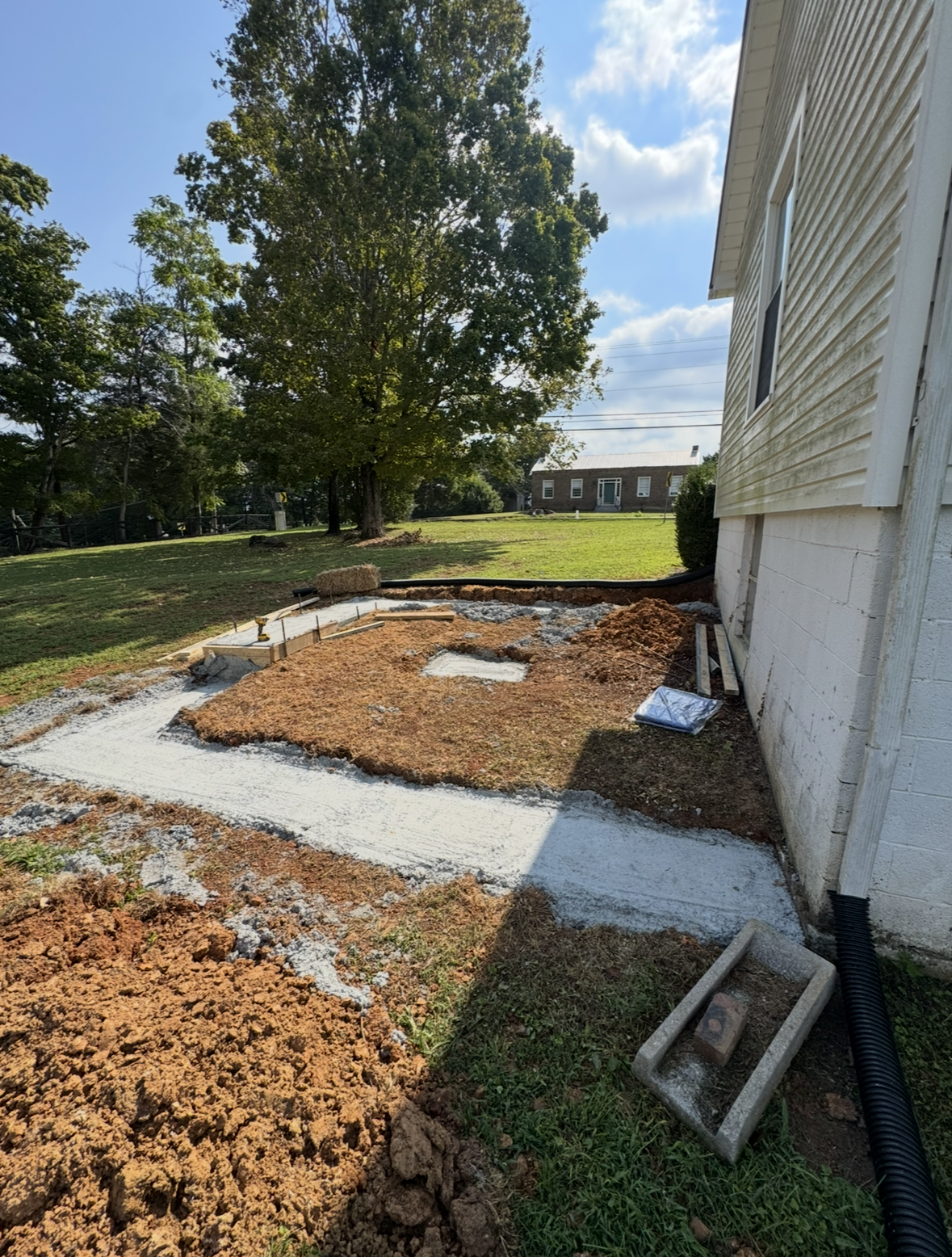 Two men are standing next to each other in front of a forest.