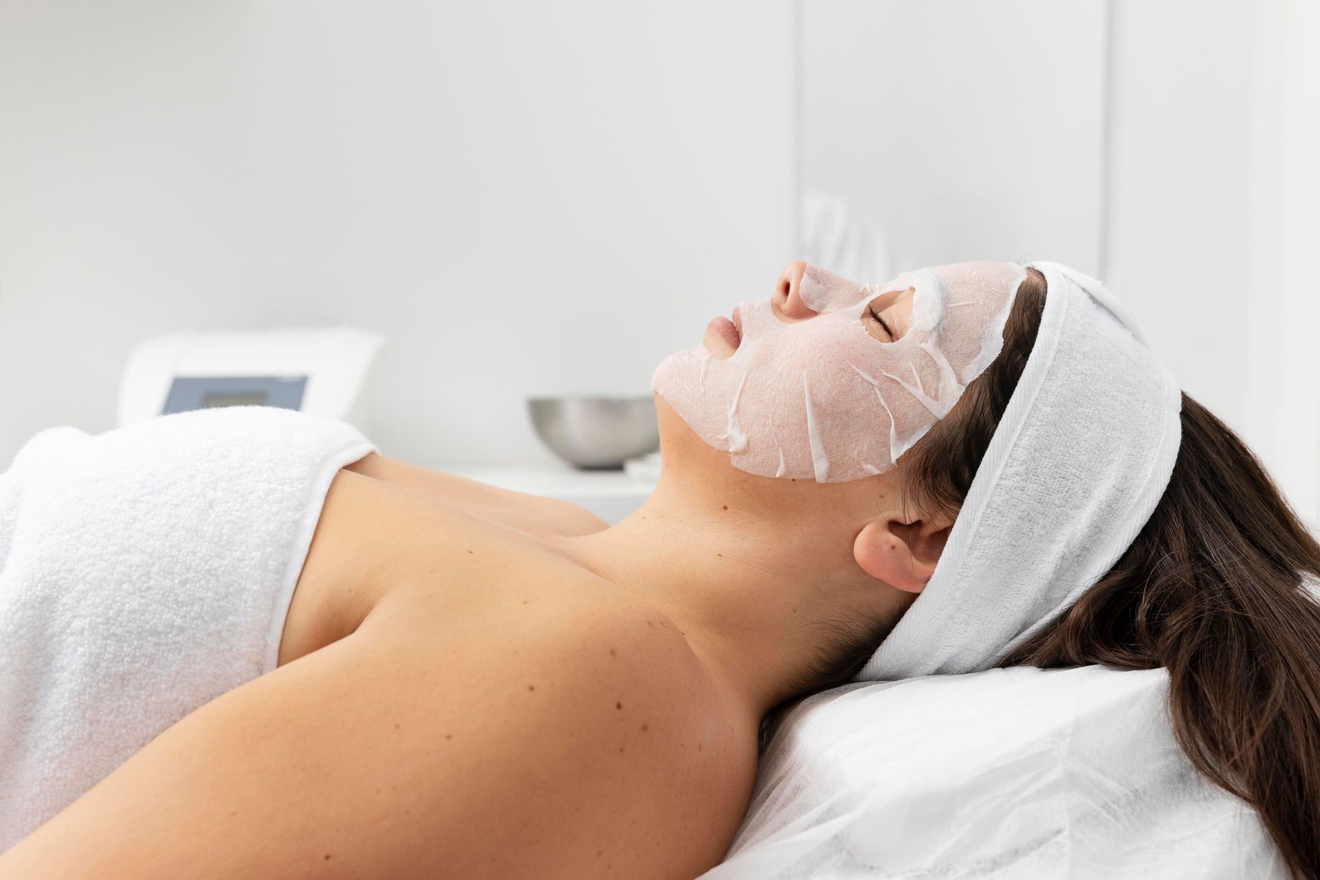 a woman is laying on a bed with a mask on her face .