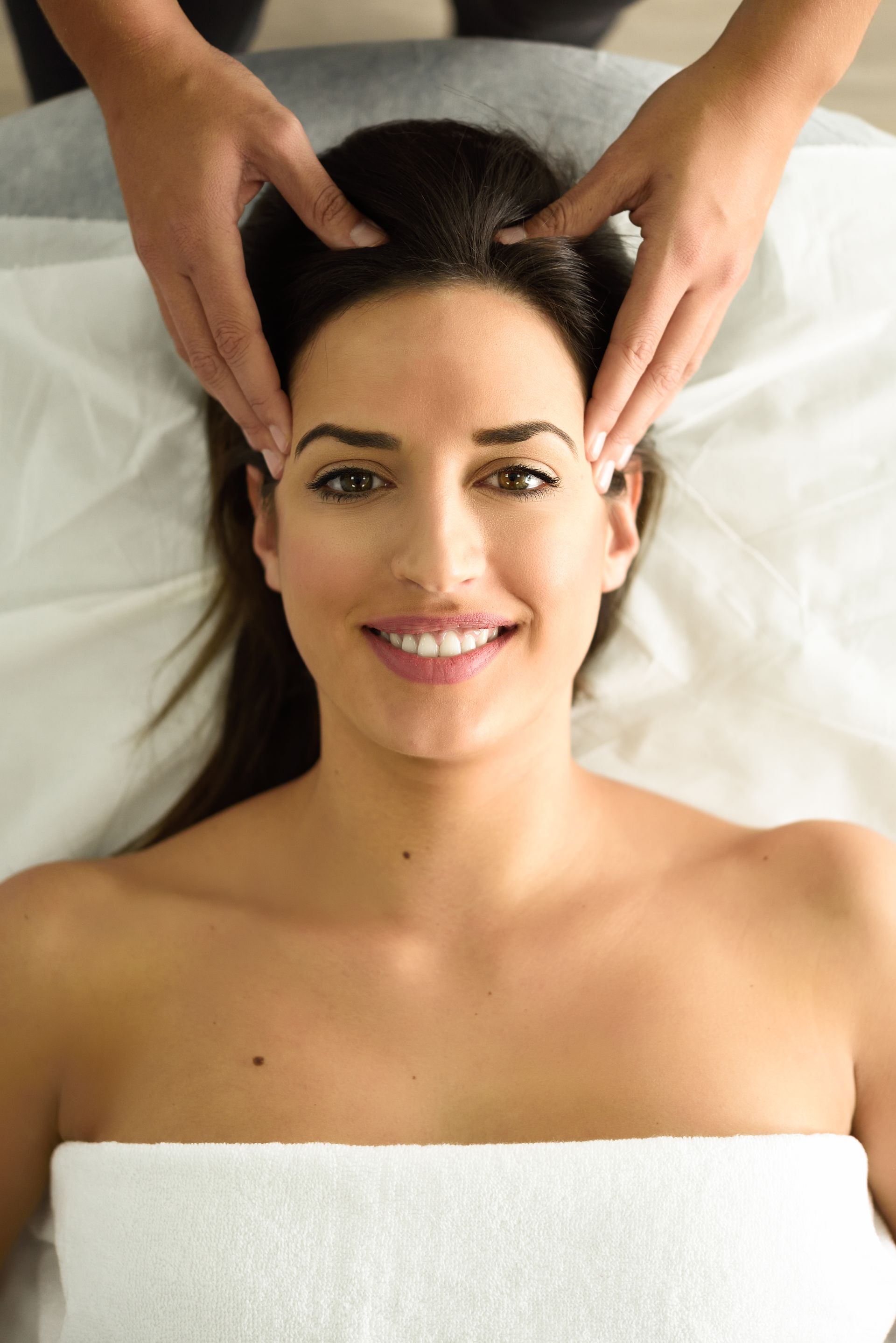 a woman is getting a head massage at a spa .