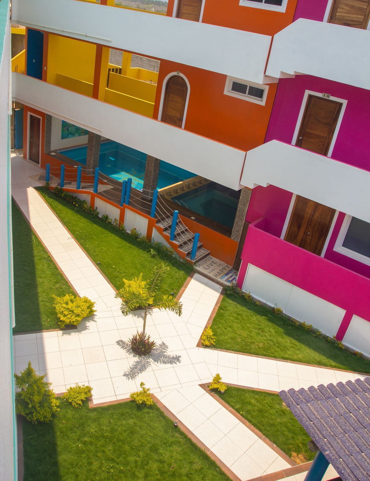An aerial view of a colorful building with a swimming pool