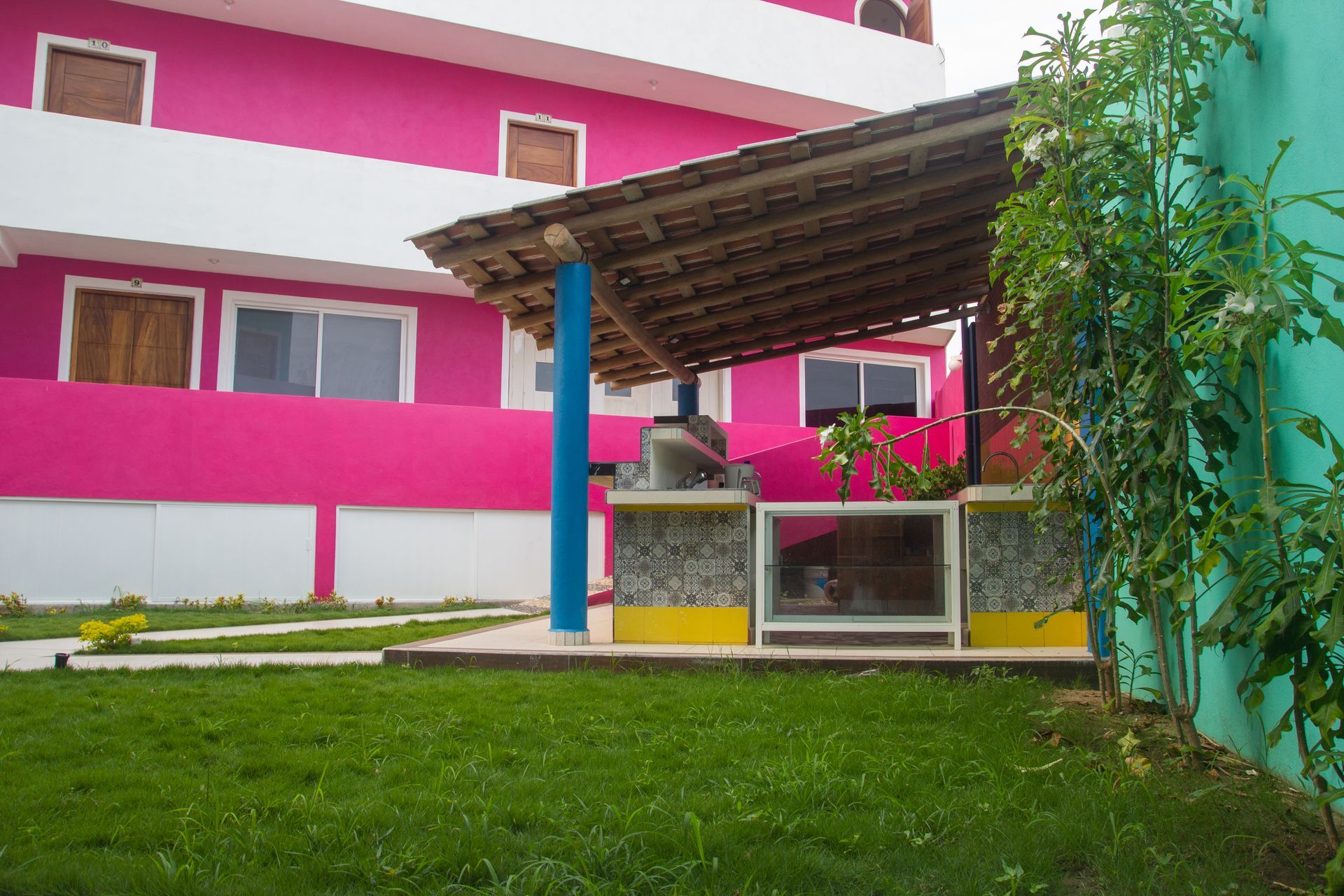 A pink building with a blue pillar in front of it