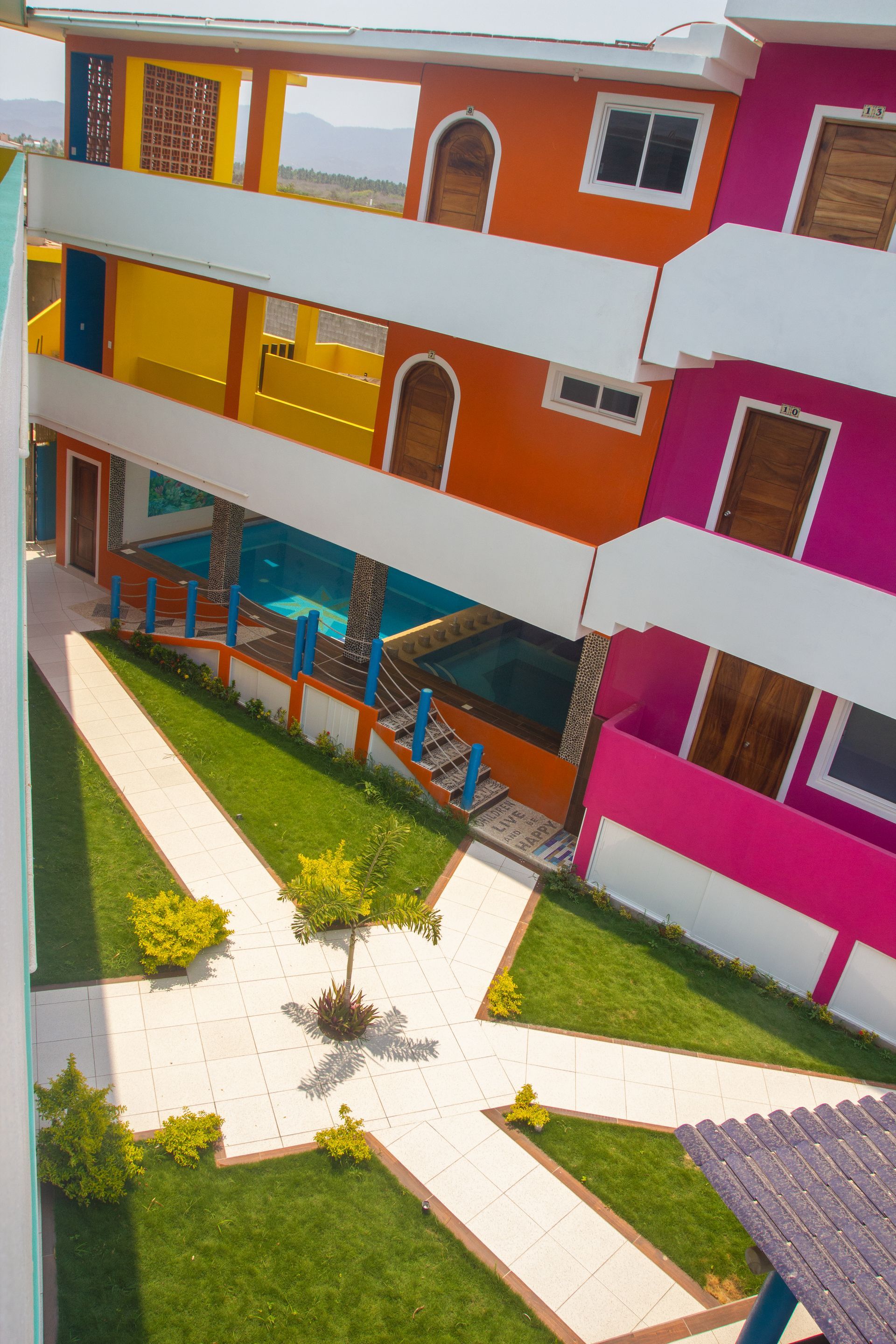 Una vista aérea de un colorido hotel con piscina.