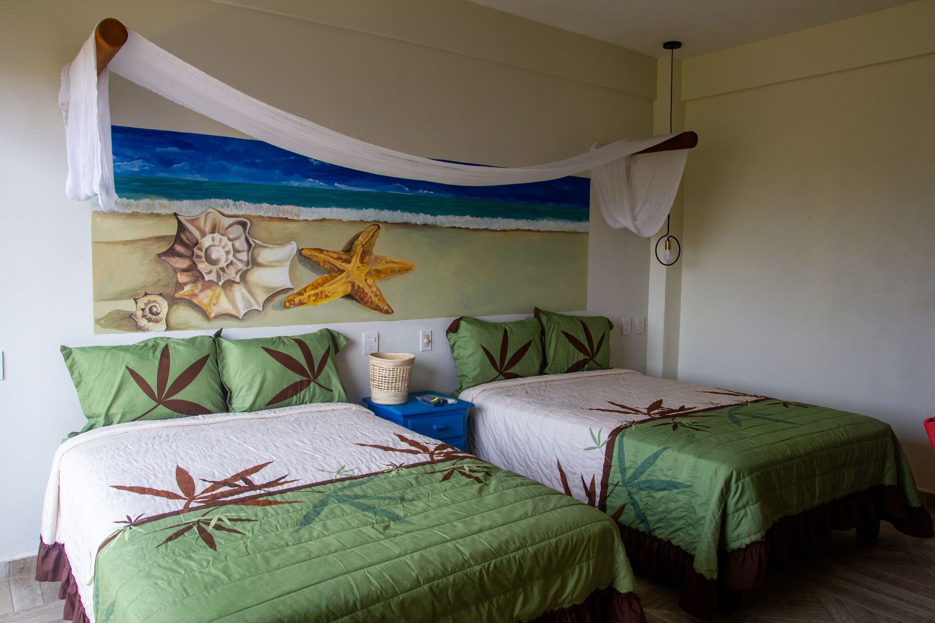 A hotel room with two beds and a painting on the wall.