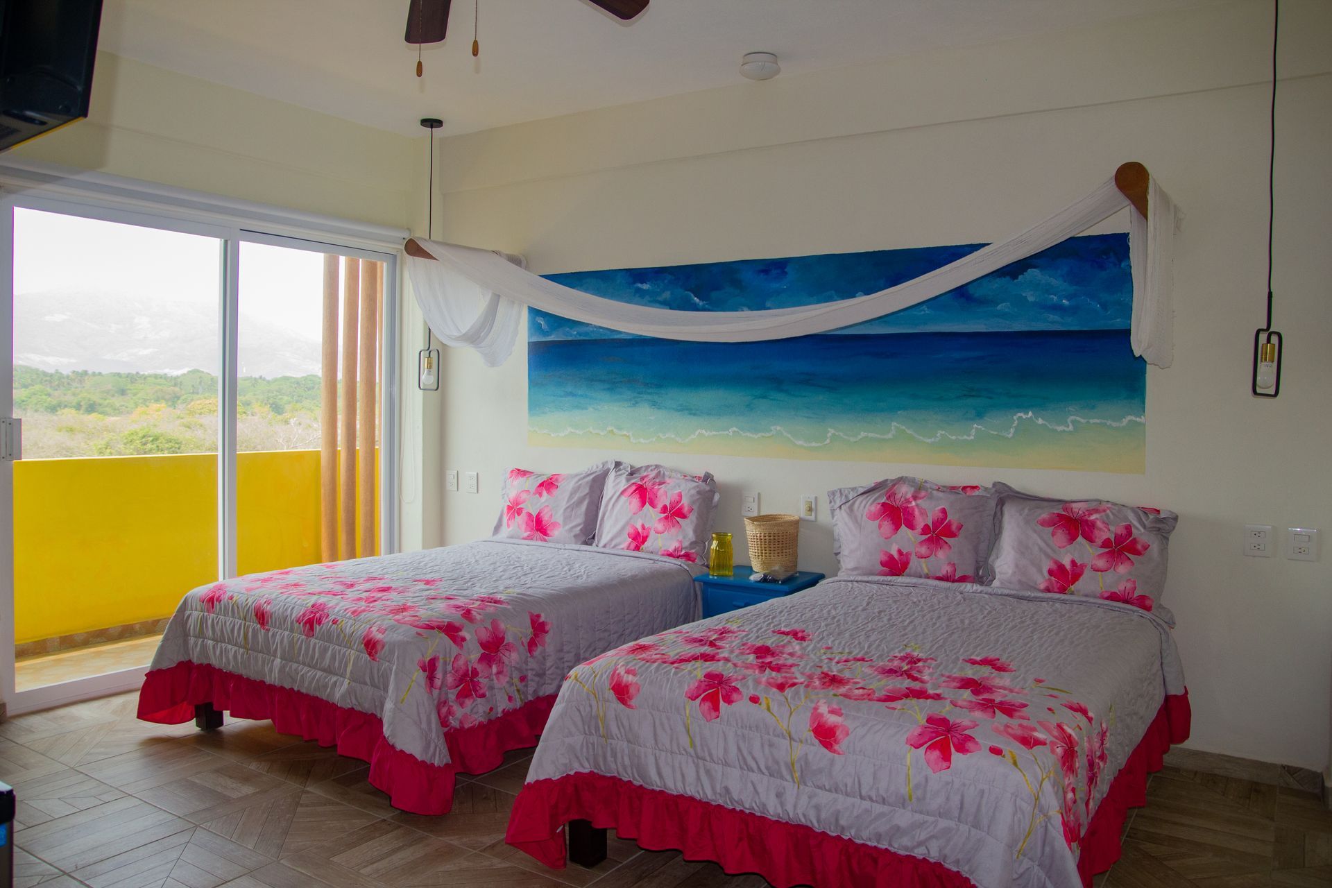 A hotel room with two beds and a painting on the wall.