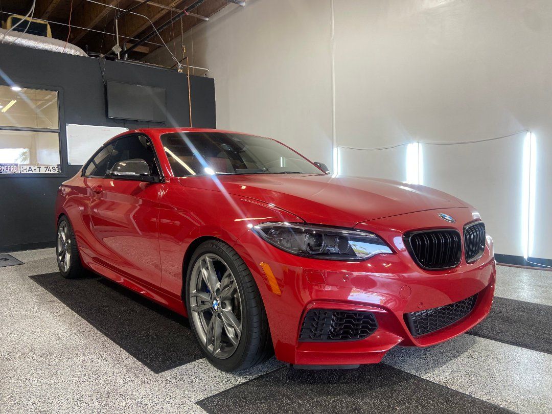 A red bmw is parked in a garage.