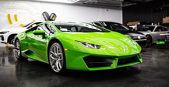 A green lamborghini huracan is parked in a garage.
