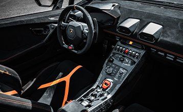 The interior of a lamborghini huracan with a steering wheel and dashboard.