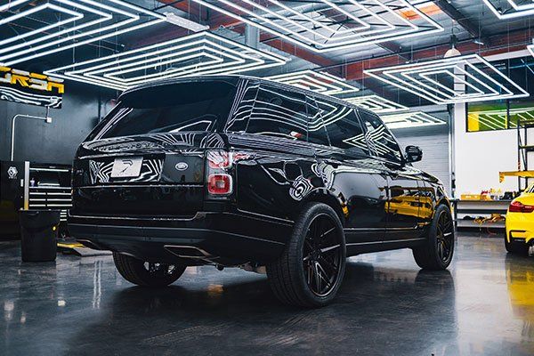 A black range rover is parked in a garage.