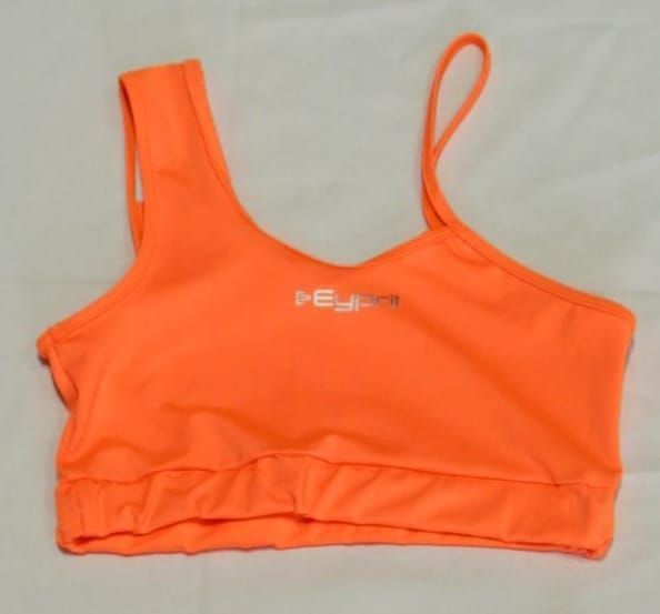 Sujetador deportivo naranja con tirante asimétrico y logo.