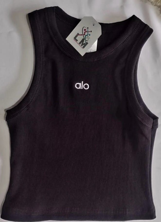 Camiseta de tirantes Alo de canalé negro con el logotipo de la marca en el pecho y una etiqueta adherida al escote.