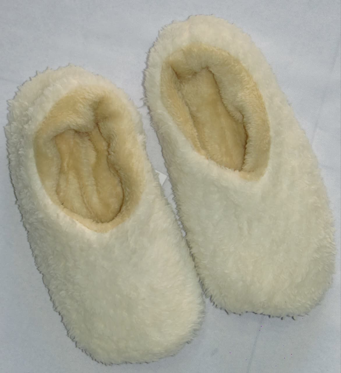 Par de pantuflas de felpa suave de color tostado.