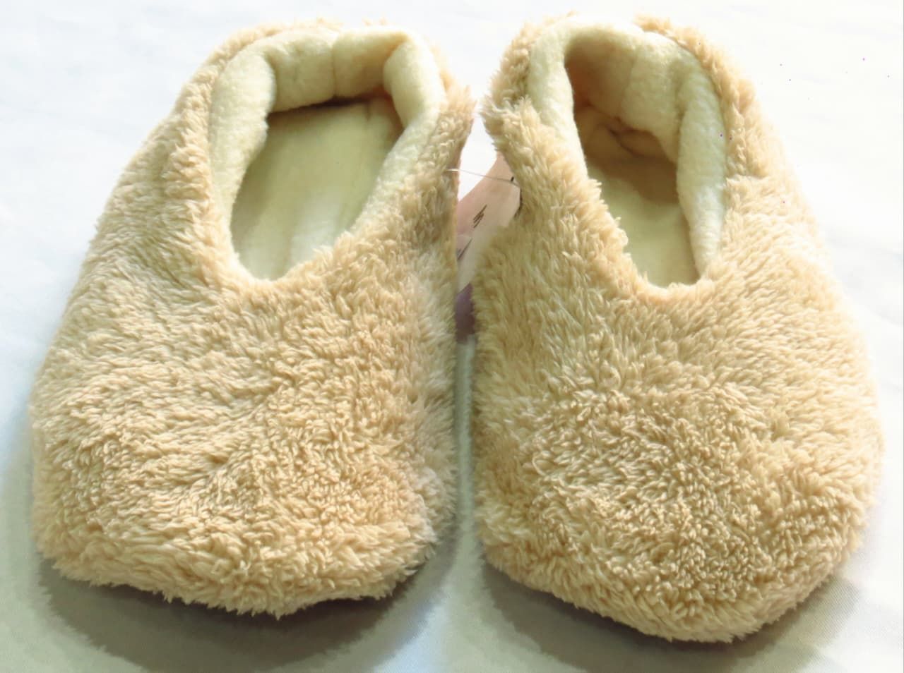 Par de pantuflas de felpa suave de color tostado.