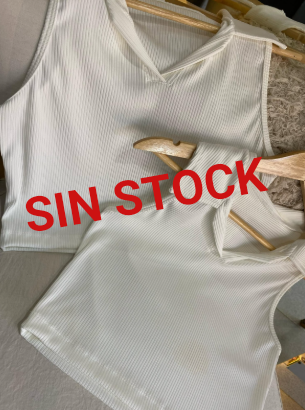 Dos camisas negras cuelgan en perchas de madera en una silla.