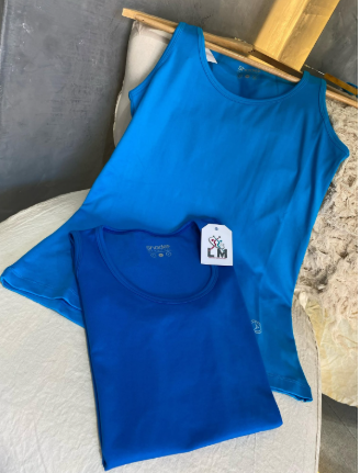 Dos camisas azules con una etiqueta que dice lm