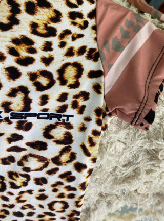 Una camisa con estampado de leopardo está colgada en una percha.