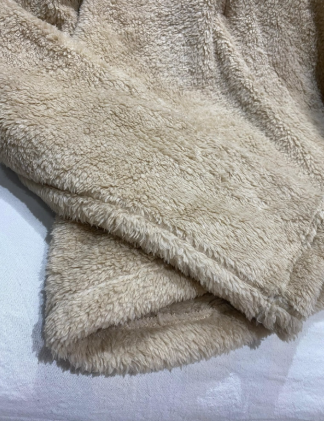 Un primer plano de una manta mullida sobre una cama.