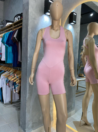 Un maniquí lleva un mono rosa en una tienda.