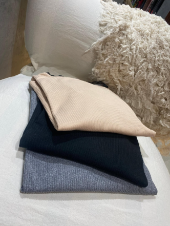 Tres piezas de tela están apiladas una encima de otra en un sofá.