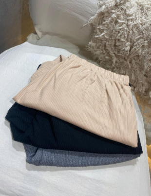 Tres piezas de tela están apiladas una encima de otra en un sofá.