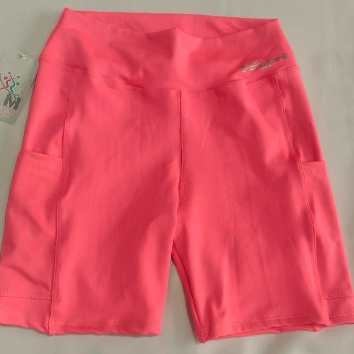 Pantalones cortos deportivos de cintura alta de color rosa brillante con bolsillos, vistos sobre una superficie blanca.