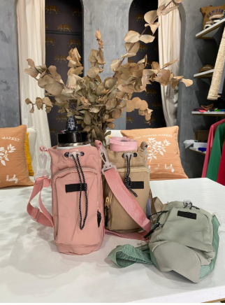 Un bolso rosa con una correa está sobre una mesa.