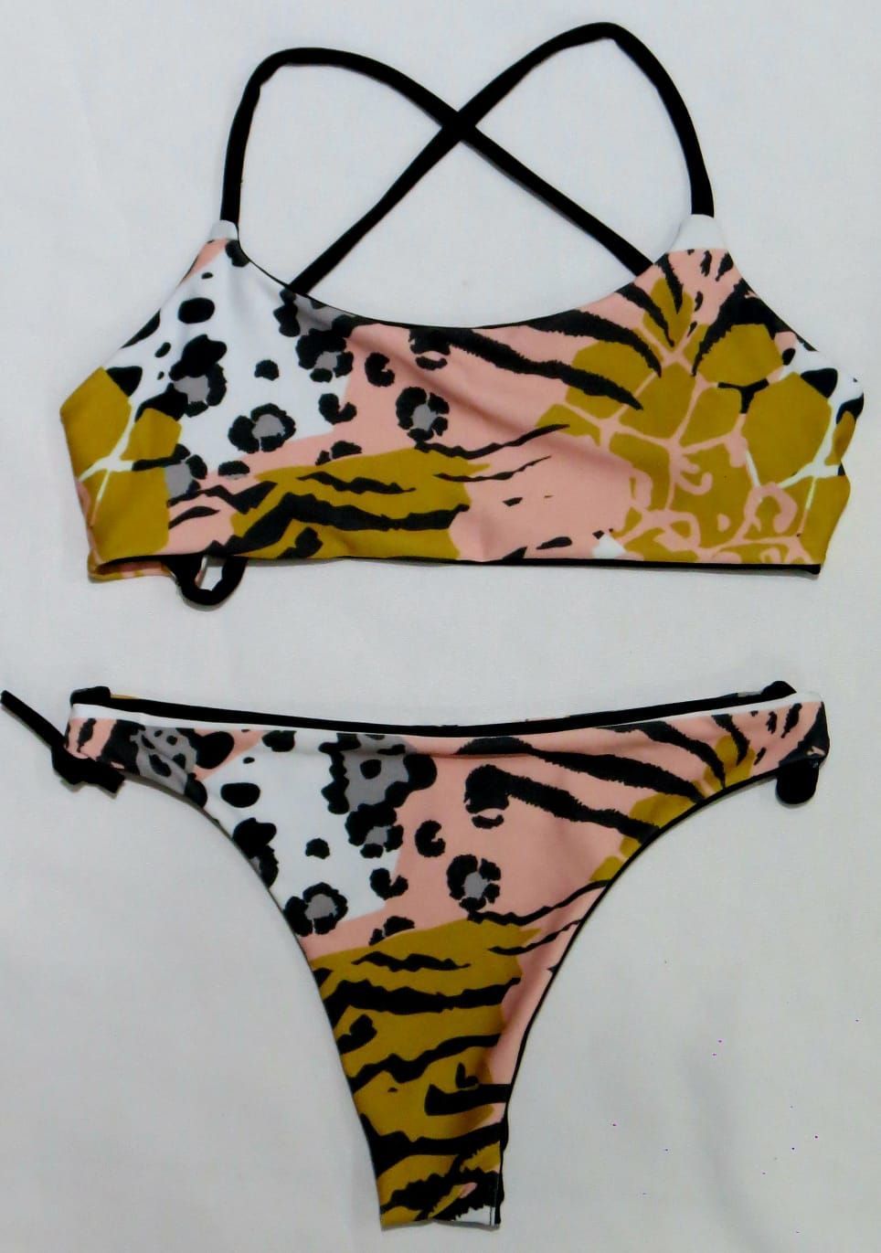 Conjunto de bikini de dos piezas con diseño geométrico en tonos melocotón, naranja, dorado y negro.