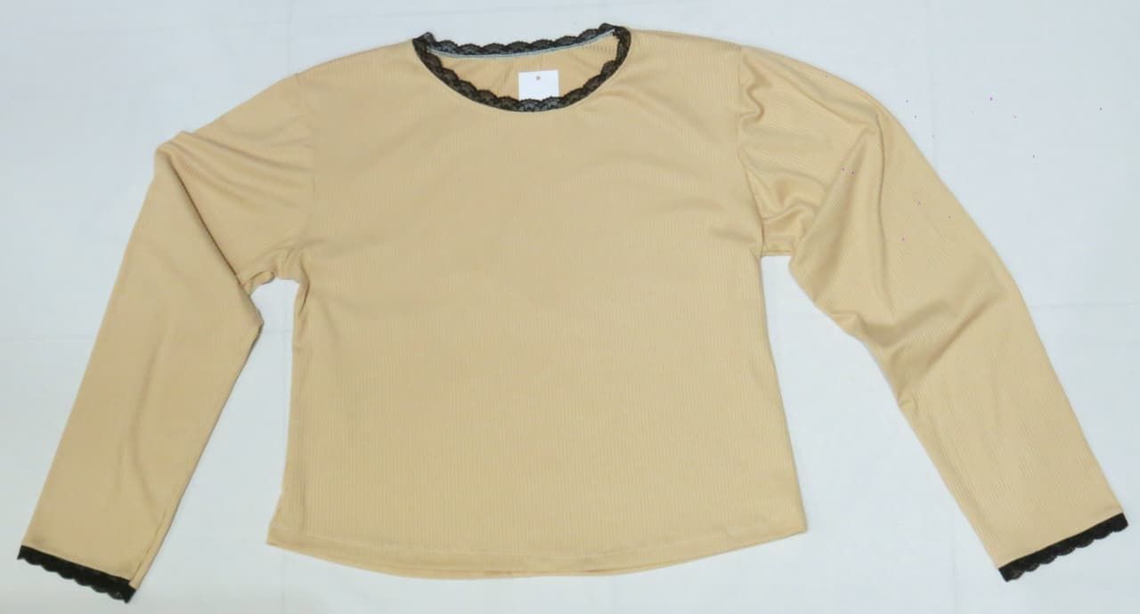 Camisa de manga larga de color beige con ribete de encaje negro alrededor del escote y puños.