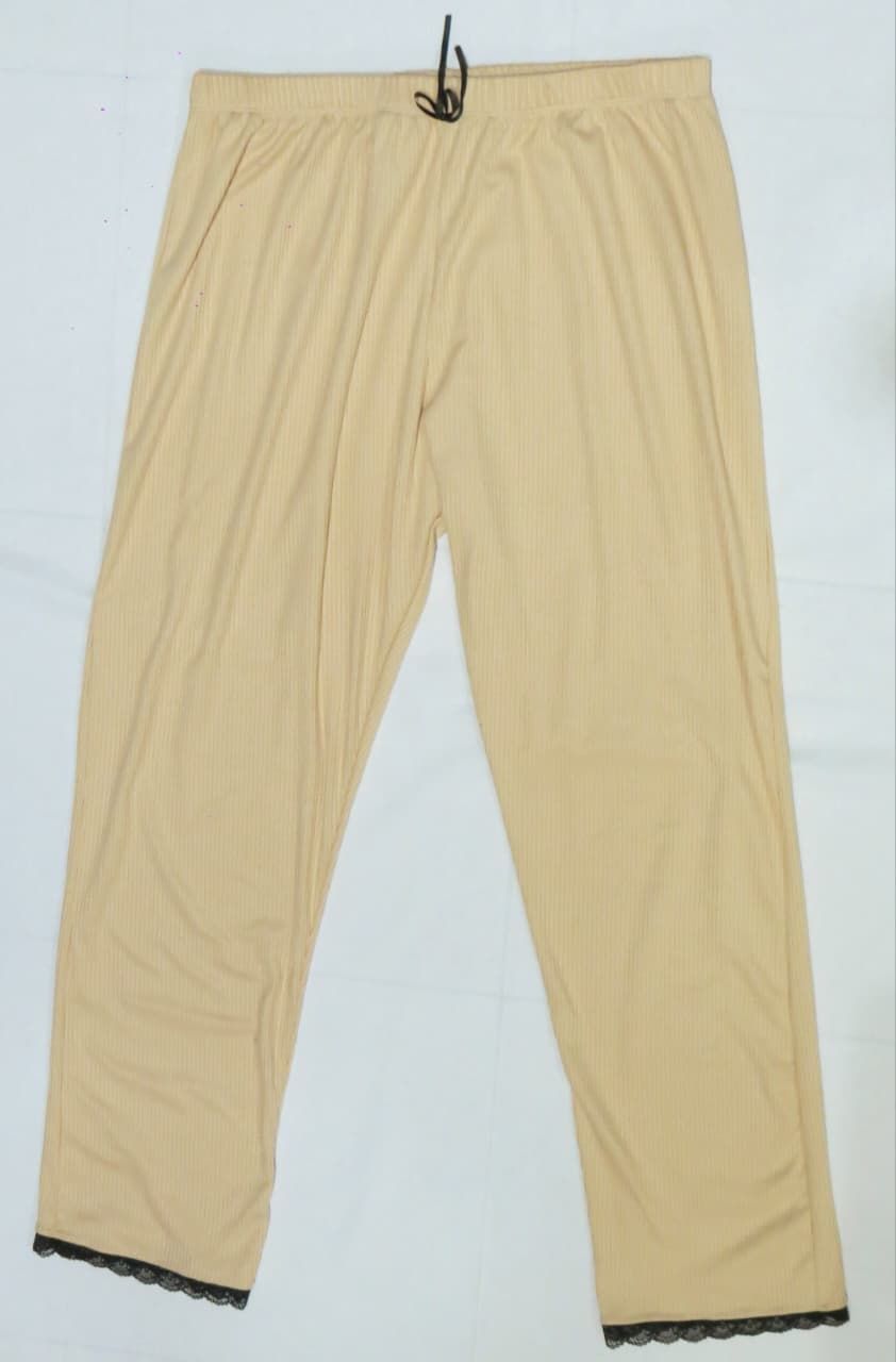 Pantalón de pijama color tostado con ribete de encaje negro en los tobillos y cinturilla con cordón.