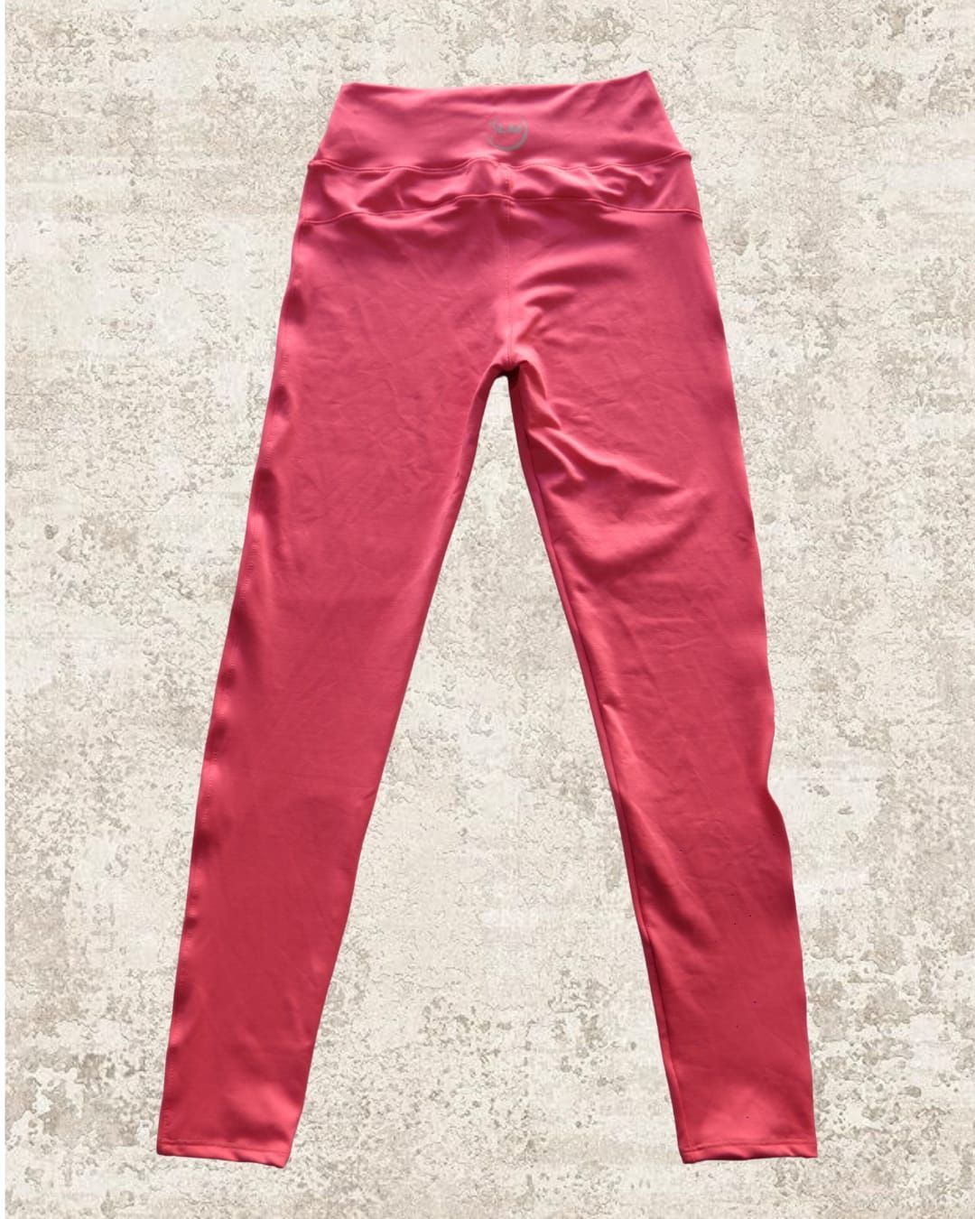 Leggings rojos con textura en tonos neutros. Diseño ajustado de cintura alta.